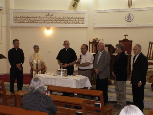 Mark Mueller, Elmarie Parker, Rob Weingartner, Elder Zuhair, Marshall Zieman, Tom Boone and Larry Richards offer communion at the Evangelical Church of Basrah, November, 2012.