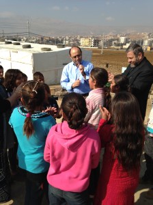Assis Fadi, moderator of the National Evangelical Synod of Syria and Lebanon encourages the children to sing and dance at an even larger refugee camp near Zahle, Lebanon, in January, 2014.