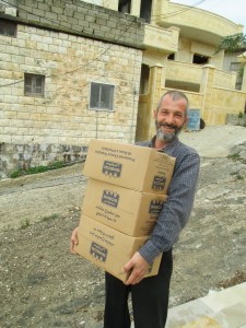 Bassam, the veterinarian from Qusayr, helps unload the truck for the food parcels.