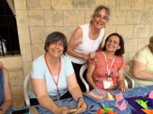 Flanked by Rev. Kate Kotfila of Cambridge, New York, and my new friend Mahsen, from Hasakeh, Syria, we fold peace cranes together.